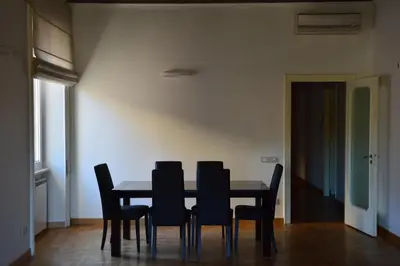 a dining room with a table and black chairs at Una finestra su Castel Sant'Angelo in Rome