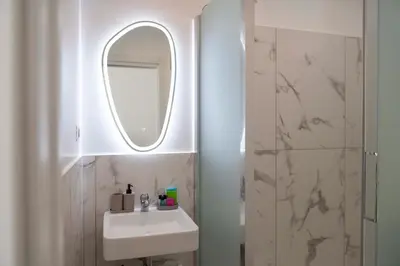 a white bathroom with a sink and a mirror at Lo Sguardo sui Re in Rome