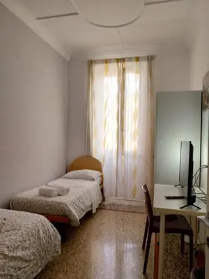 a bedroom with two beds and a desk and a television at Lo Sguardo sui Re in Rome