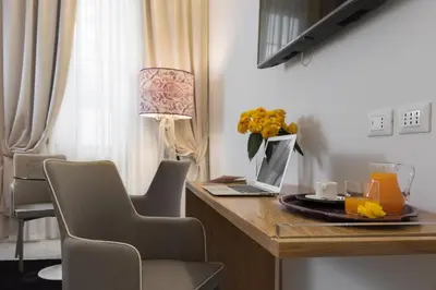 a desk with a laptop and a vase of flowers at Cavour Suites Guest House in Rome