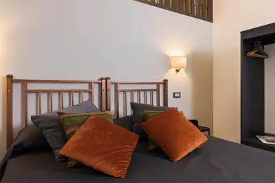 a bedroom with a bed with two pillows on it at Cavour Suites Guest House in Rome