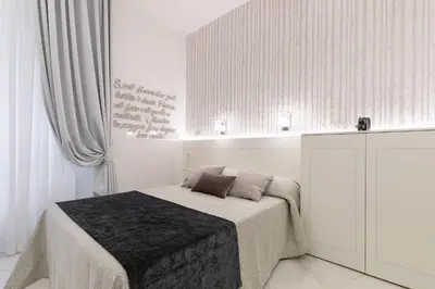 a white bedroom with a bed and a cabinet at Cavour Suites Guest House in Rome