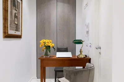 a desk with a laptop and a vase of flowers on it at Cavour Suites Guest House in Rome