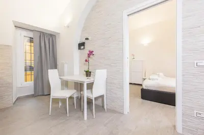 a dining room with a table and chairs and a bed at Suite House Vaticano in Rome