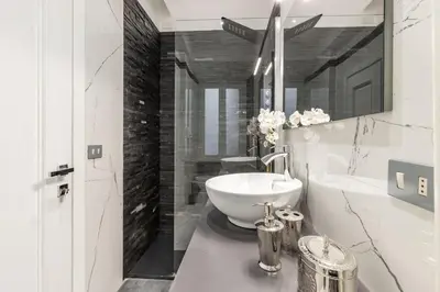 a white bedroom with a large white bed with pillows at Daphne Suites in Rome