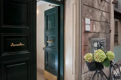 a bedroom with a large bed and a night stand at Daphne Suites in Rome