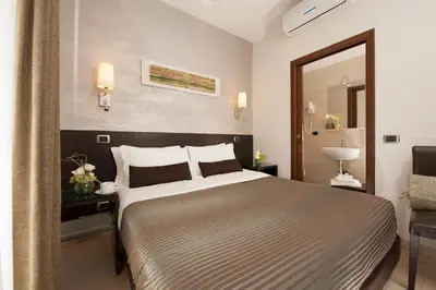 a bedroom with a large bed and a mirror at Daphne Suites in Rome