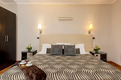a bedroom with a large bed with a cat sitting on it at Daphne Suites in Rome