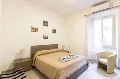 a bedroom with a bed and a chair and a window at Vacanze romane holidays in Rome