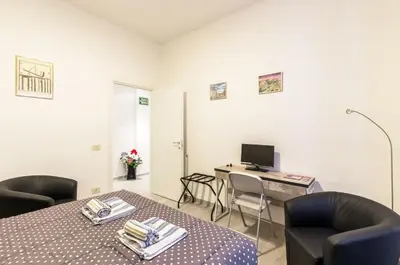 a room with a table and chairs and a desk with a computer at Vacanze romane holidays in Rome