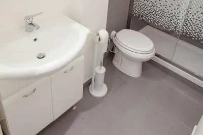 a white bathroom with a toilet and a sink at Vacanze romane holidays in Rome