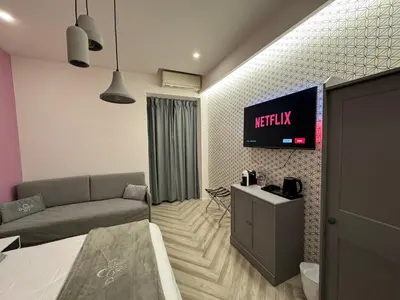 a living room with a couch and a tv on the wall at Domus Avi Vaticano in Rome