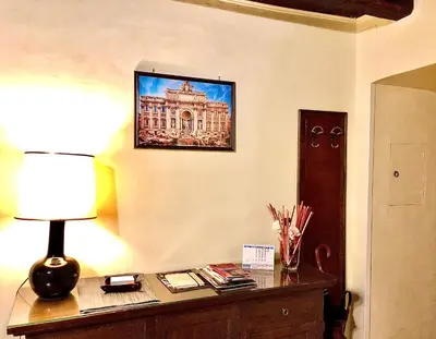 a desk with a lamp and a picture of a building at La Tana al Flaminio in Rome