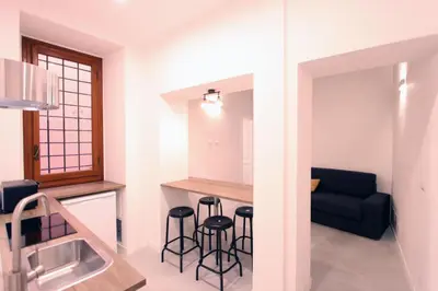 a kitchen and living room with a couch and stools at Monte Giordano Flats in Rome
