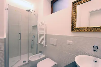 a bathroom with a toilet and a sink and a mirror at Monte Giordano Flats in Rome