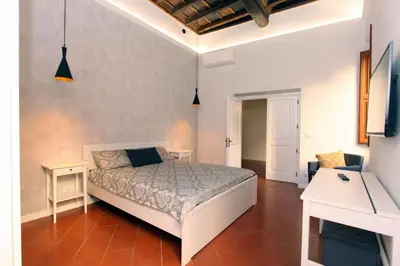 a bedroom with a bed and a desk and a tv at Monte Giordano Flats in Rome