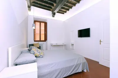 a white bedroom with a bed and a tv at Monte Giordano Flats in Rome
