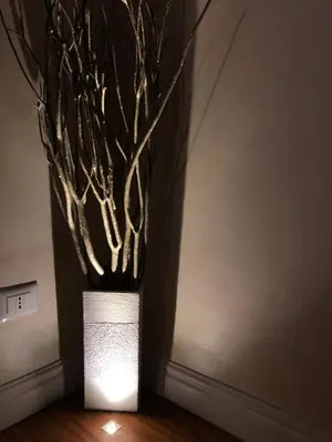 a white vase with branches in a room at Luxury Apartment Frattina 34 Anelli in Rome