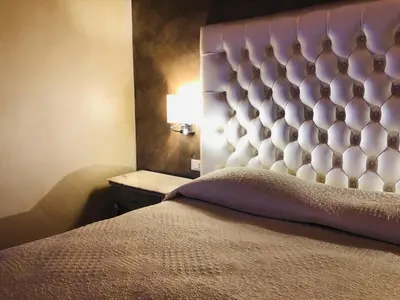 a bedroom with a bed with a large headboard at Luxury Apartment Frattina 34 Anelli in Rome