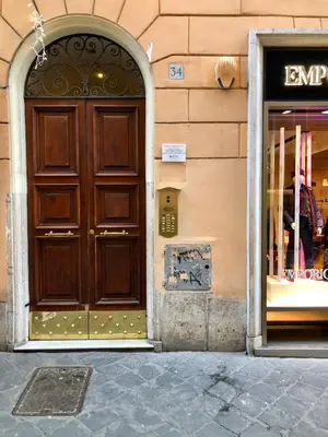 a large wooden door on the side of a building at Luxury Apartment Frattina 34 Anelli in Rome