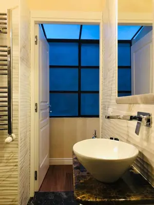 a bathroom with a white sink and a window at Luxury Apartment Frattina 34 Anelli in Rome