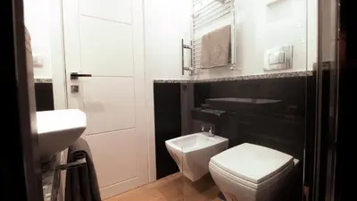 a bathroom with a white toilet and a sink at Urbanflat Roma in Rome