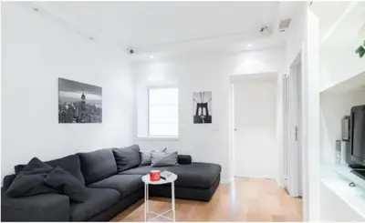 a living room with a black couch and a table at Urbanflat Roma in Rome