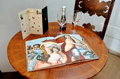 a table with a book and a glass of wine at Raffaello Charmsuite in Rome