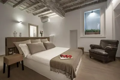 a dining room table with two chairs and a bottle of wine at Raffaello Charmsuite in Rome