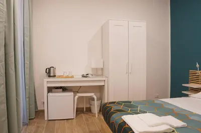 a bedroom with a bed and a desk and a table at Roma Trasteverina in Rome