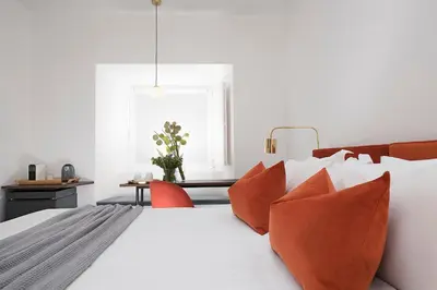 a bedroom with a white bed with orange pillows at Maison Ottavia in Rome