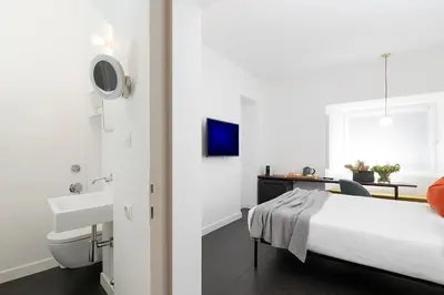 a bedroom with a bed and a sink and a desk at Maison Ottavia in Rome