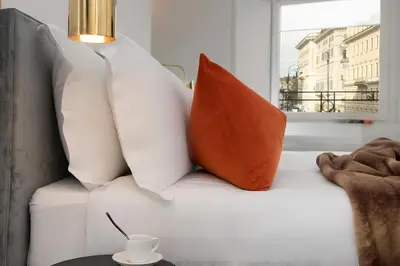 a white couch with two pillows and a cup on a table at Maison Ottavia in Rome