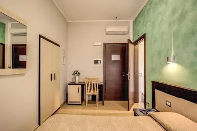 a bedroom with a bed and a table with a chair at Buonarroti Suite in Rome