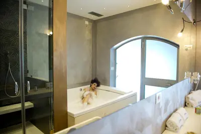 a woman sitting in a bath tub in a bathroom at Wrooms Guest House in Rome