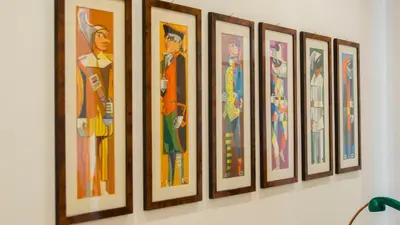 a row of framed art on a wall at Mid House in Rome