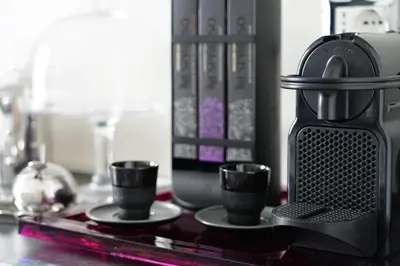 a coffee maker and three cups on a table at Mid House in Rome
