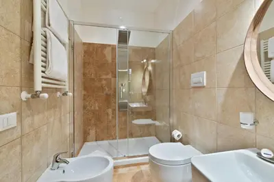 a bathroom with a shower and a toilet and a sink at Vatican Domus Luxury Rooms in Rome