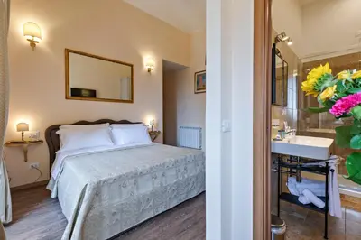 a bedroom with a bed and a sink and a mirror at Vatican Domus Luxury Rooms in Rome