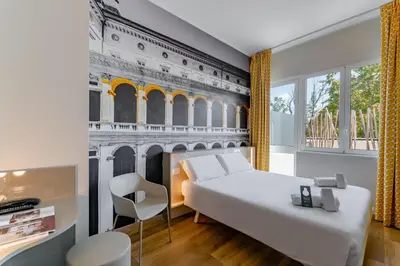 a bedroom with a white bed and a building mural at B&B Hotel Roma Pietralata Tiburtina in Rome
