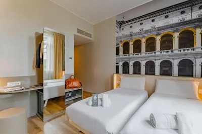 a bedroom with two beds and a mural of the coliseum at B&B Hotel Roma Pietralata Tiburtina in Rome