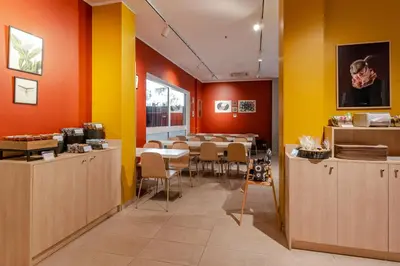 a dining room with a table and yellow and orange walls at B&B Hotel Roma Pietralata Tiburtina in Rome