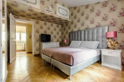 a bedroom with a large bed with pink floral wallpaper at T-House Fontana di Trevi in Rome