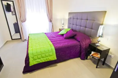 a bedroom with a purple bed with a green blanket at Domus Fontis in Rome