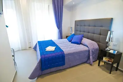 a bedroom with a large bed with blue and purple at Domus Fontis in Rome