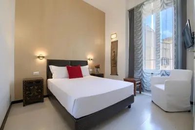 a bedroom with a white bed and a white chair at Alloggio per uso turistico D'Ambrosio Antonella Gli Scipioni 53 in Rome