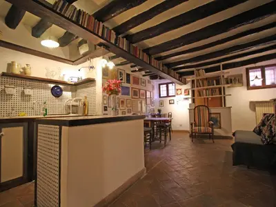 a kitchen and living room with a bar and a table at Terrace Apartment - Heart of Trastevere in Rome