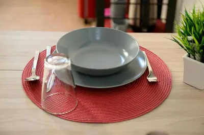 a bowl on a red plate on a table at La dolce casa di Giulia in Rome