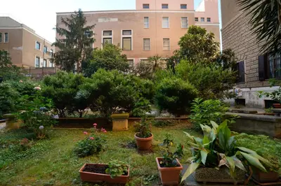 a garden with potted plants in front of a building at La dolce casa di Giulia in Rome