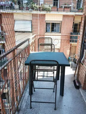 a black table and a chair on a balcony at Checchi House in Rome